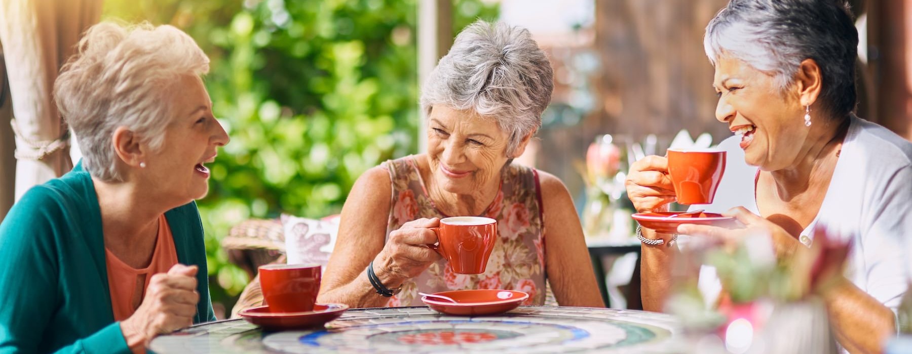 a group of women sitting at a table with cups of coffee